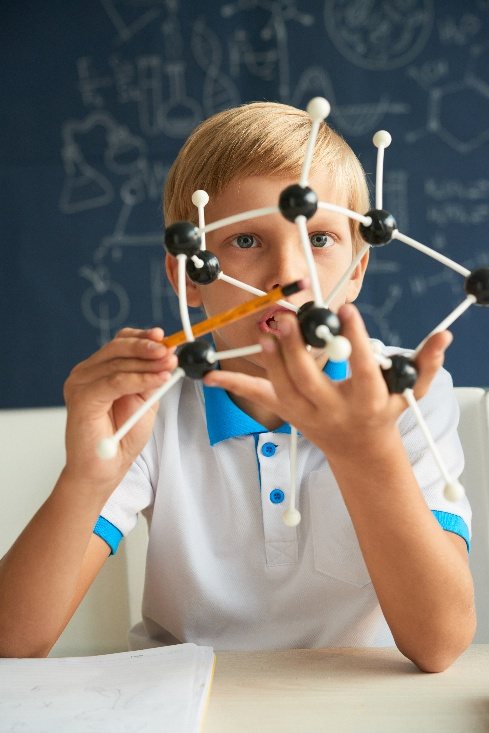 Niño observando un modelo molecular en una sesión de altas capacidades