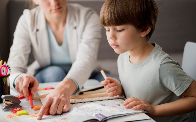 Pedagoga trabajando con un niño con material manipulativo sobre la mesa